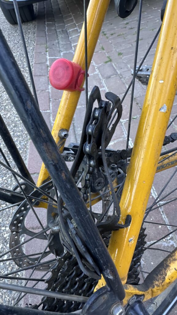 Picture of a back wheel of a ycicle with a mangled rear derailleur.